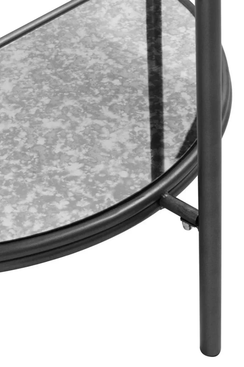 Black metal table leg with round glass shelf and textured finish close up