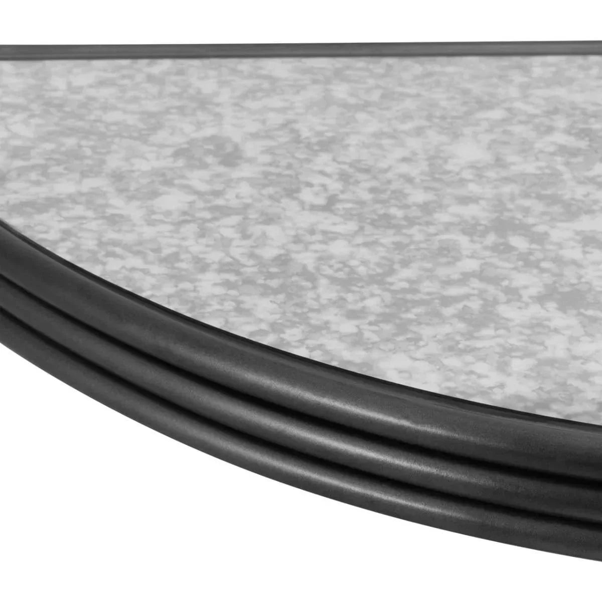 Closeup of round glass table top with black metal rim and speckled surface detail