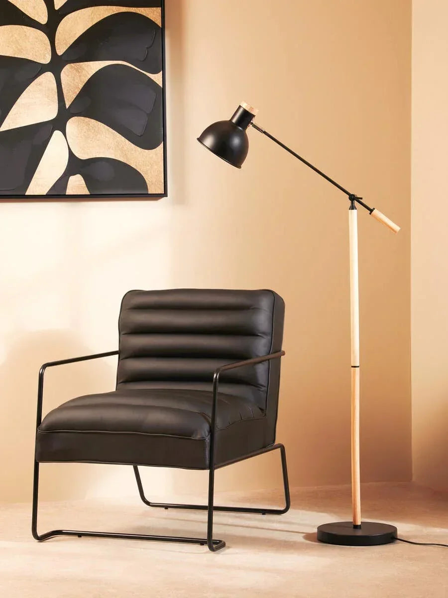 Black leather armchair with metal frame and floor lamp in modern living room