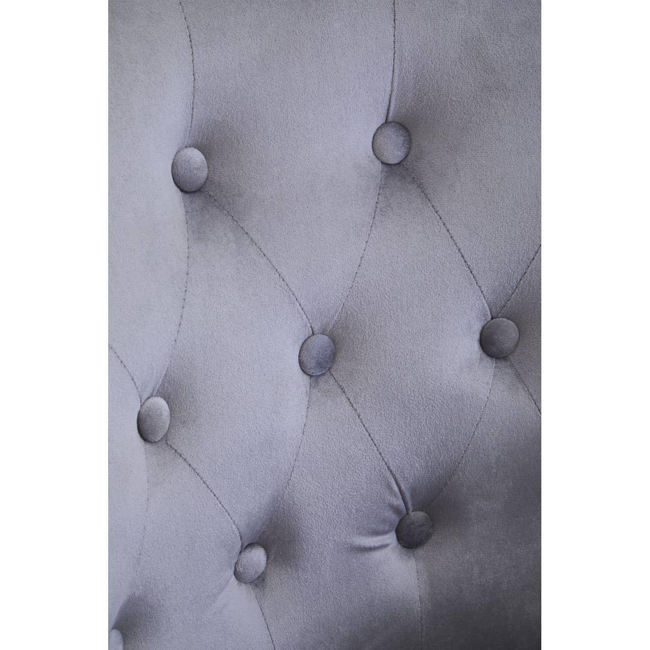 Close up of grey velvet upholstered headboard with button tufting detail