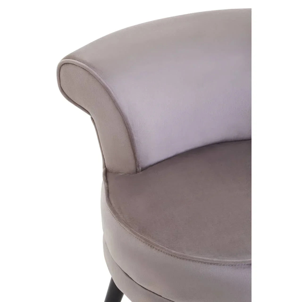 Close-up of grey velvet accent chair with curved backrest and black legs