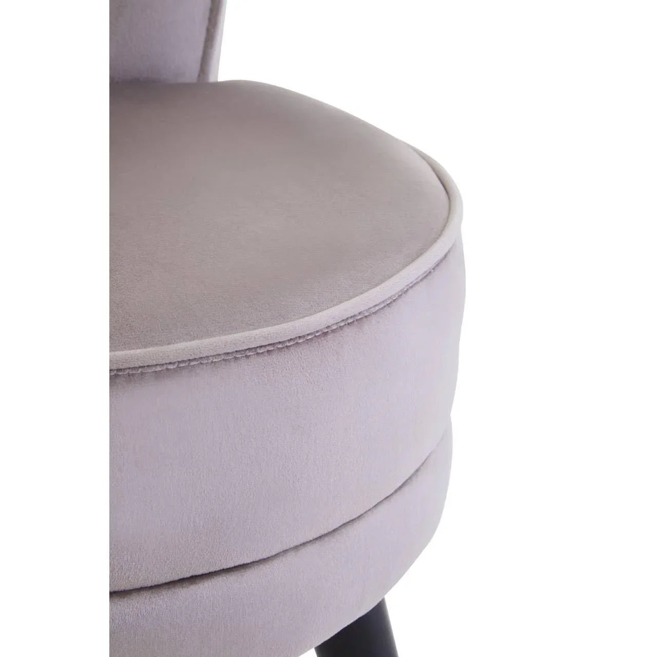 Close-up of light grey velvet dining chair seat with soft upholstery and black wooden leg