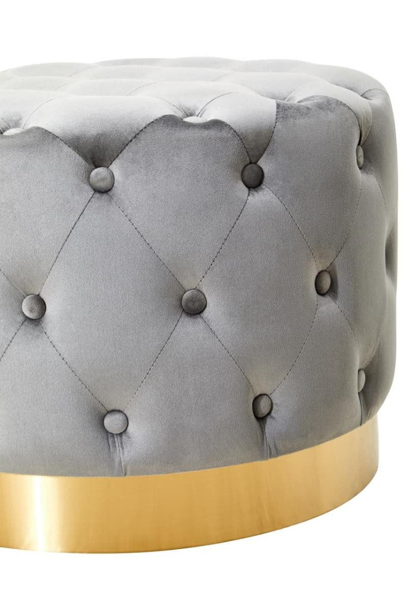 Round grey velvet stool featuring a tufted design with decorative buttons and a matte gold finish metal base. The stool has a plush, soft surface and a sleek, modern aesthetic