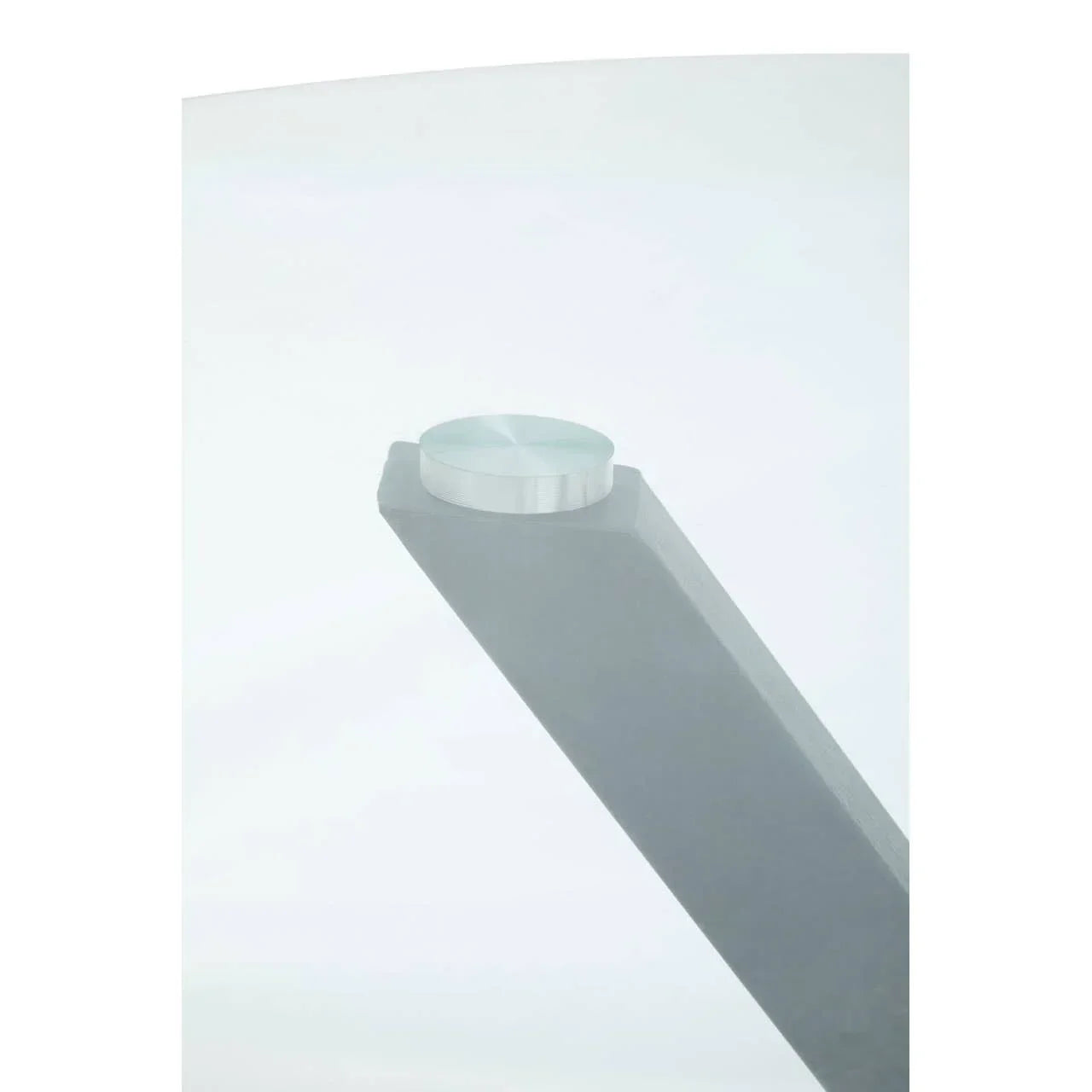 Close-up of glass dining table top with grey metal leg and brushed steel connector
