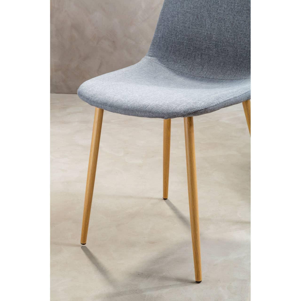Grey fabric dining chair with wooden legs on light stone floor, front side view