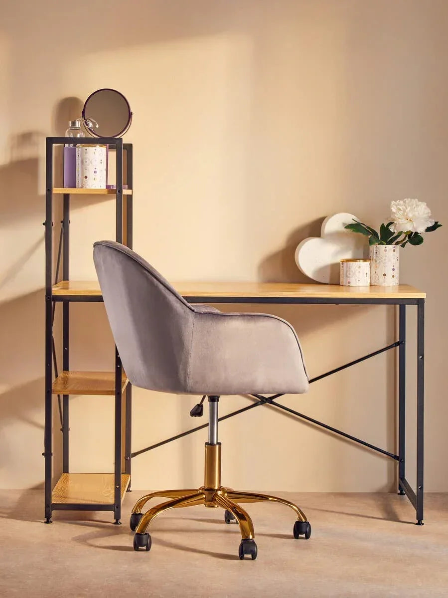 Velvet office chair with gold base at modern wooden desk and metal shelving unit