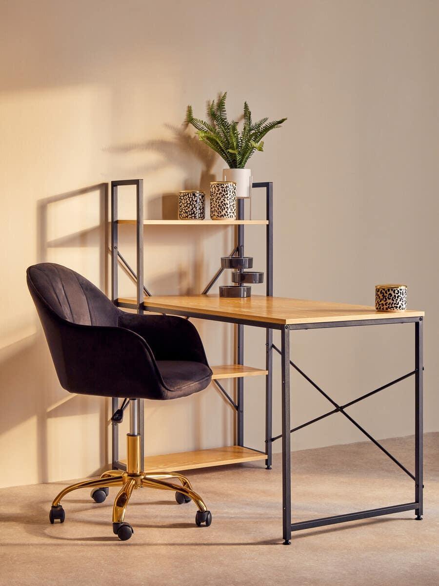 Black office chair with gold base beside wood and metal desk with shelves and decor items