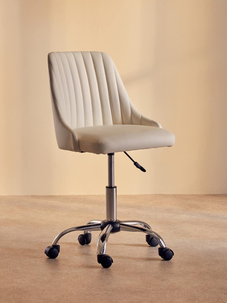 Beige upholstered office chair with chrome base and wheels on neutral background