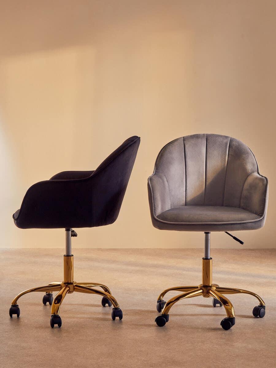 Velvet office chairs with gold swivel bases, one in grey front view, one in black side view