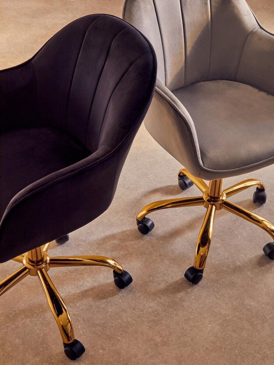 Velvet office chairs with gold swivel bases in black and grey finish, side by side on carpet