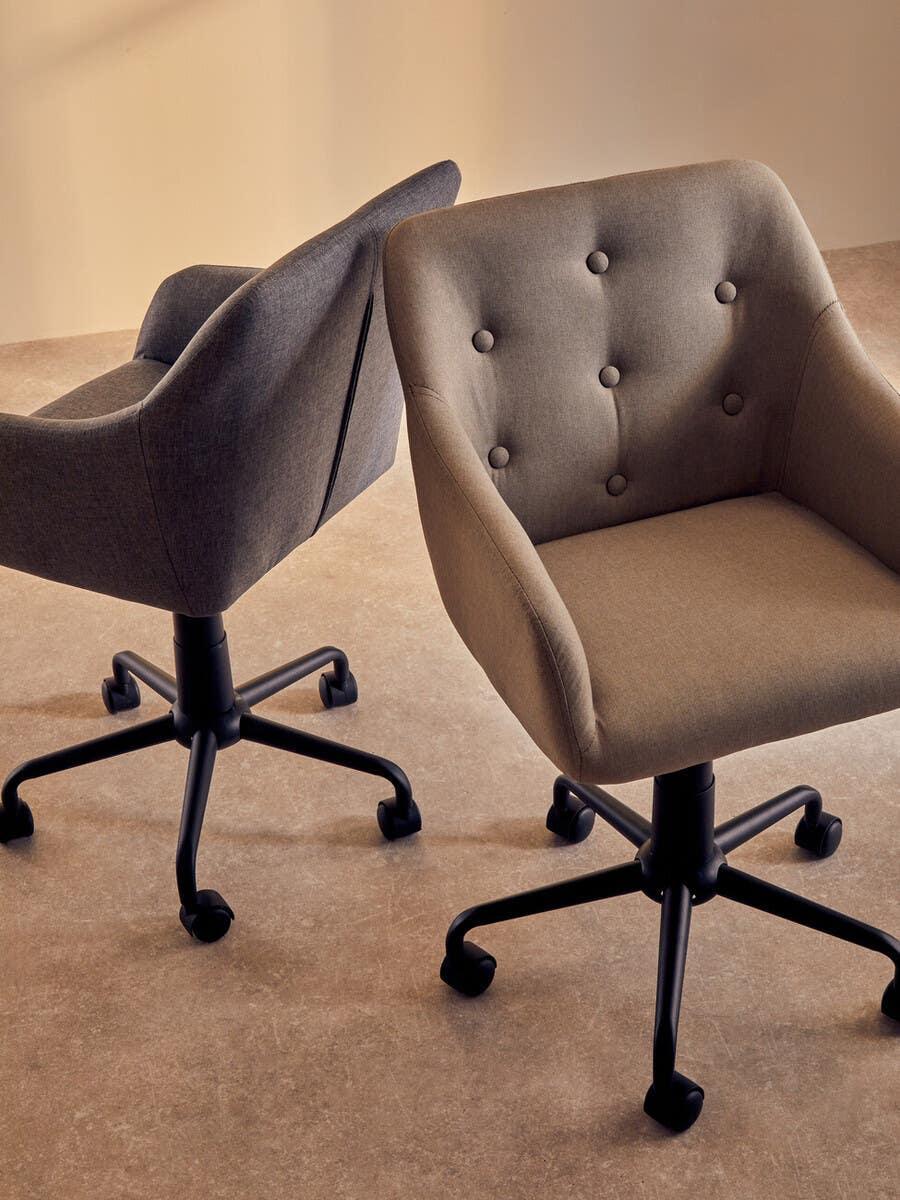 Two fabric office chairs with button back detail and black wheeled bases on beige flooring
