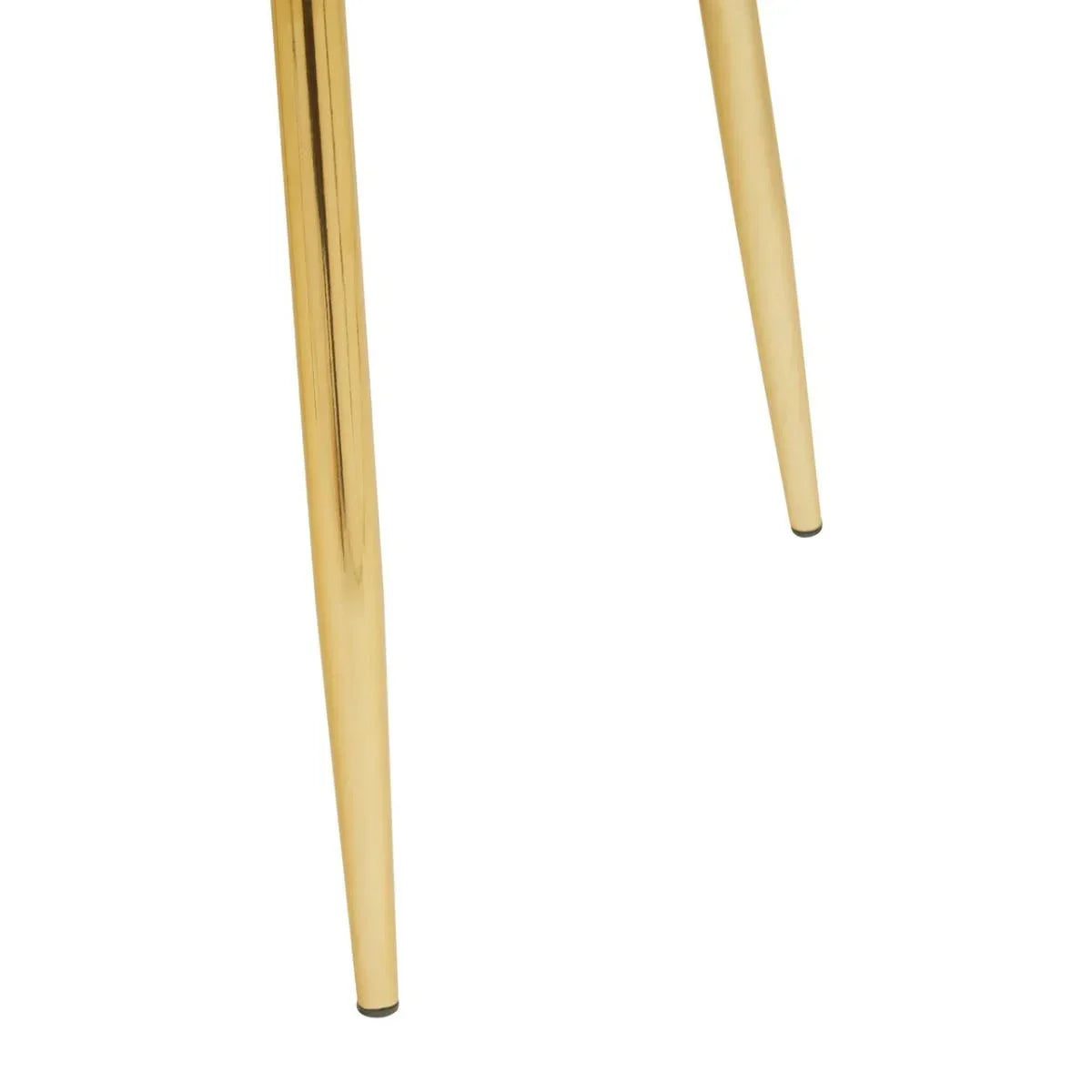 Close up of gold metal furniture legs with tapered design