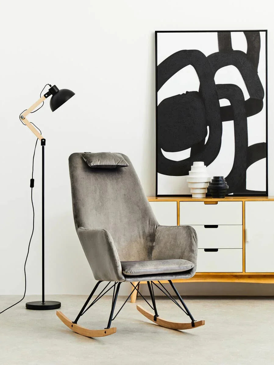 Grey velvet rocking chair with black metal legs in modern living room setting