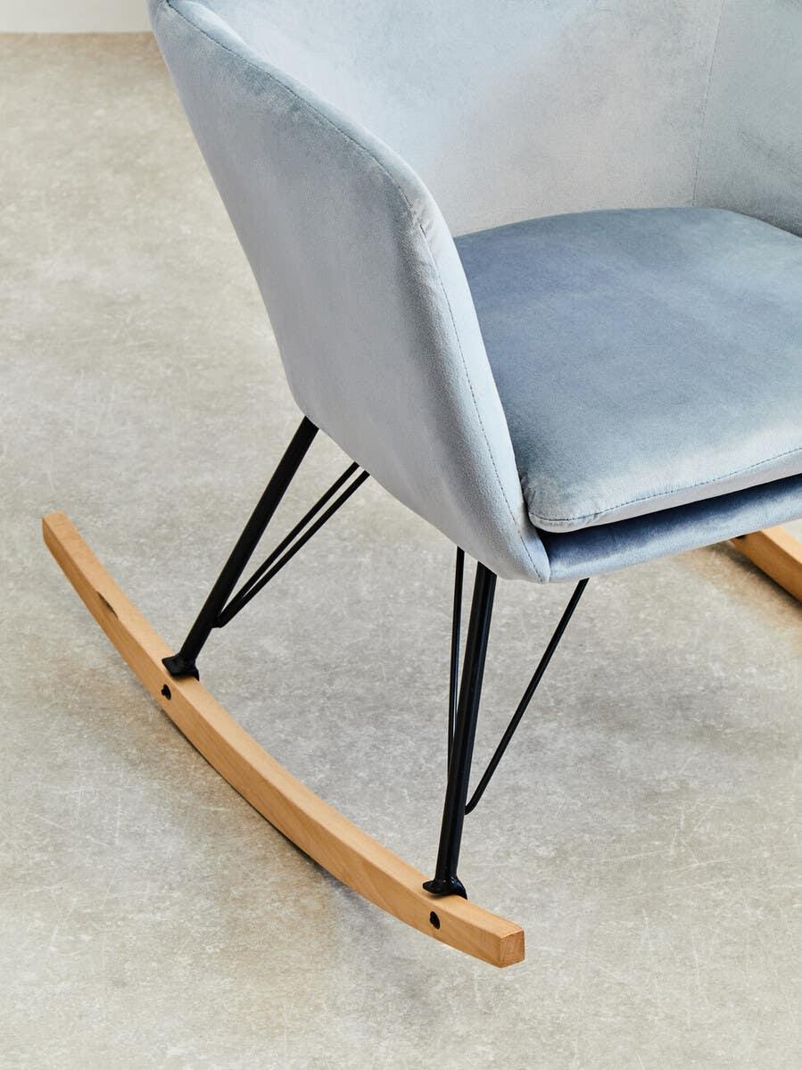 Light grey fabric rocking chair with black metal legs and natural wood runners on tile floor