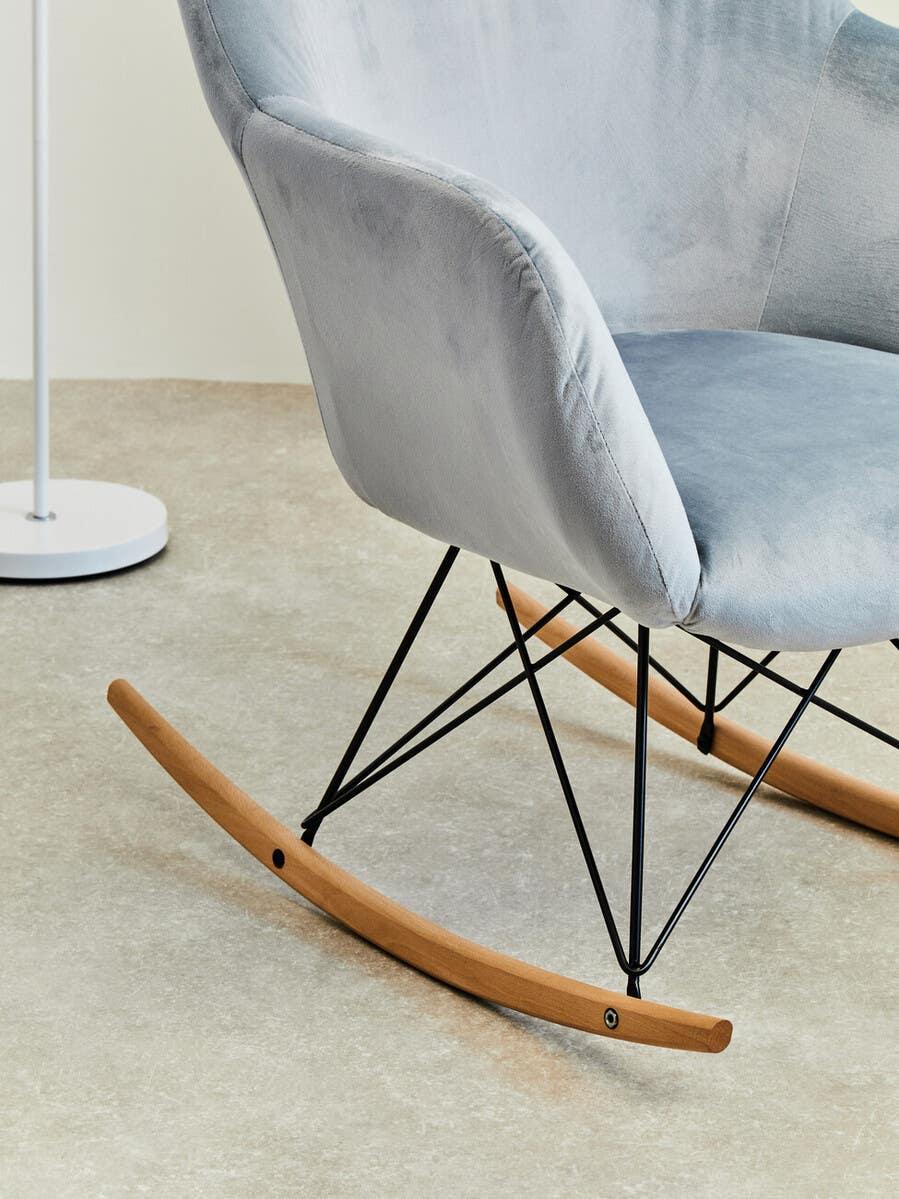 Light grey velvet rocking chair with wooden runners and black metal legs on tiled floor