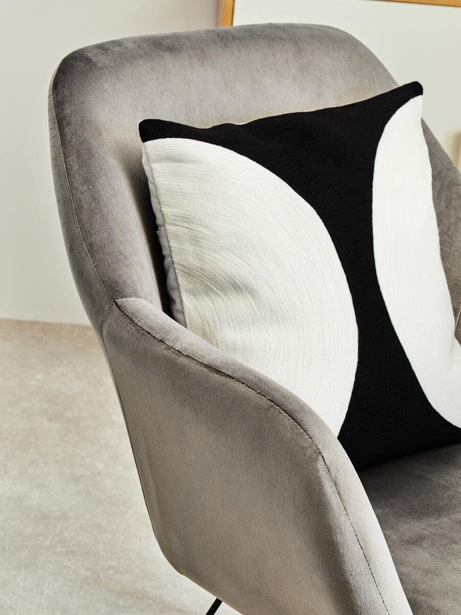 Grey velvet accent chair with modern black and white geometric scatter cushion