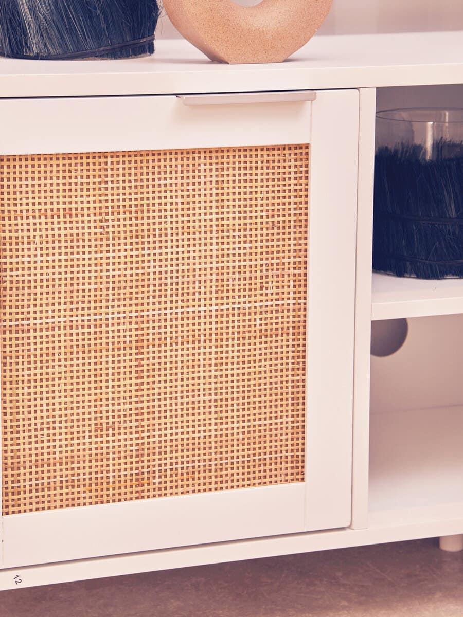 White sideboard cabinet with woven rattan door and open shelf detail
