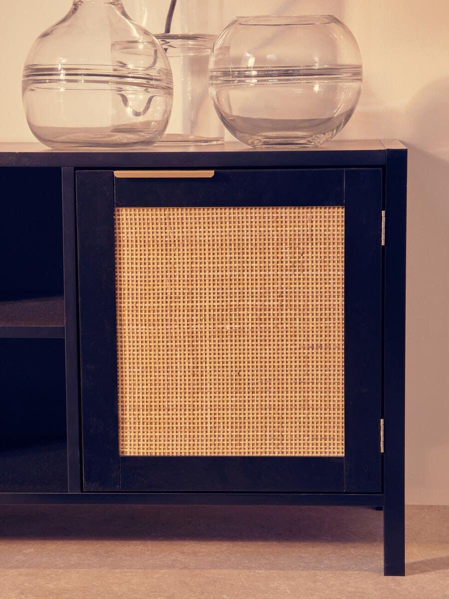 Black wood sideboard with woven rattan cabinet door and glass vases on top