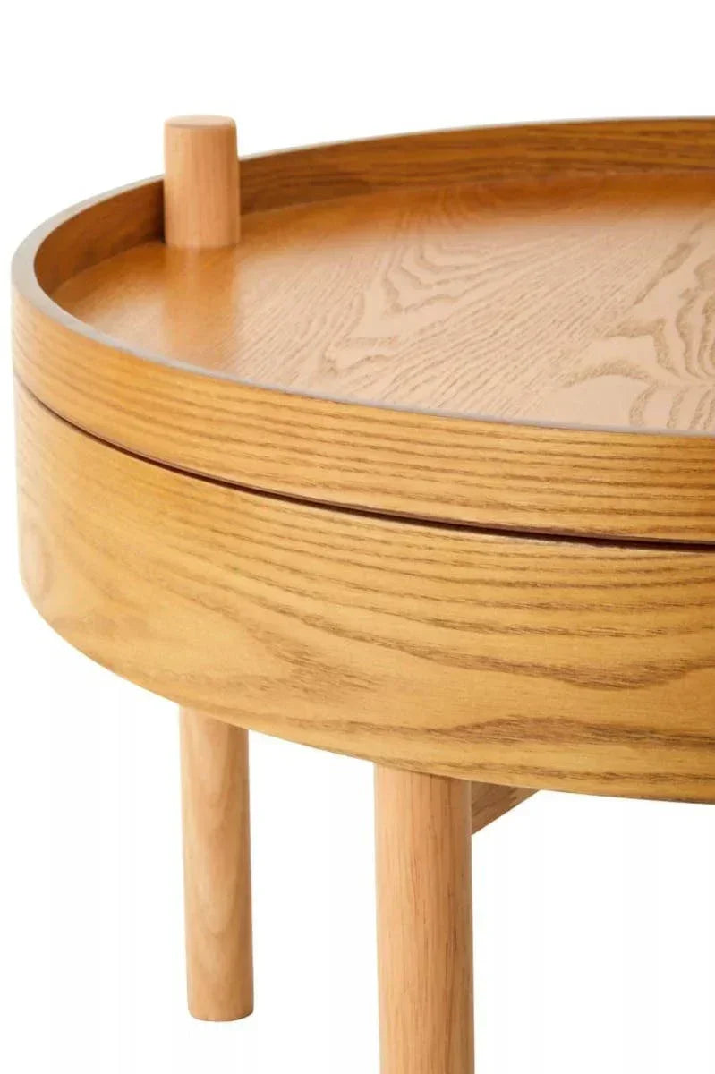 Light oak round coffee table with raised edge and solid wood legs, closeup view