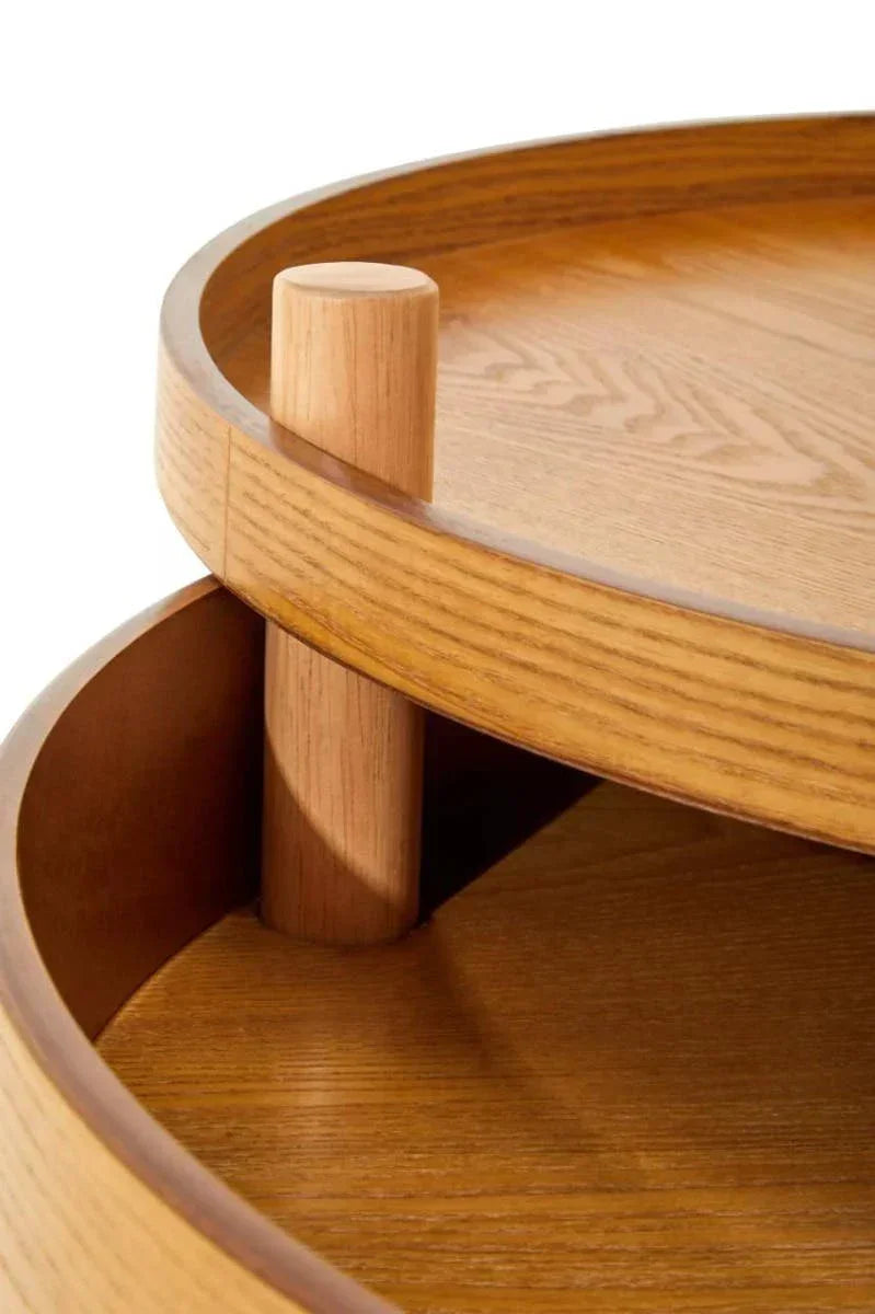 Round oak coffee table with two-tier shelves and wood grain detail, close-up view