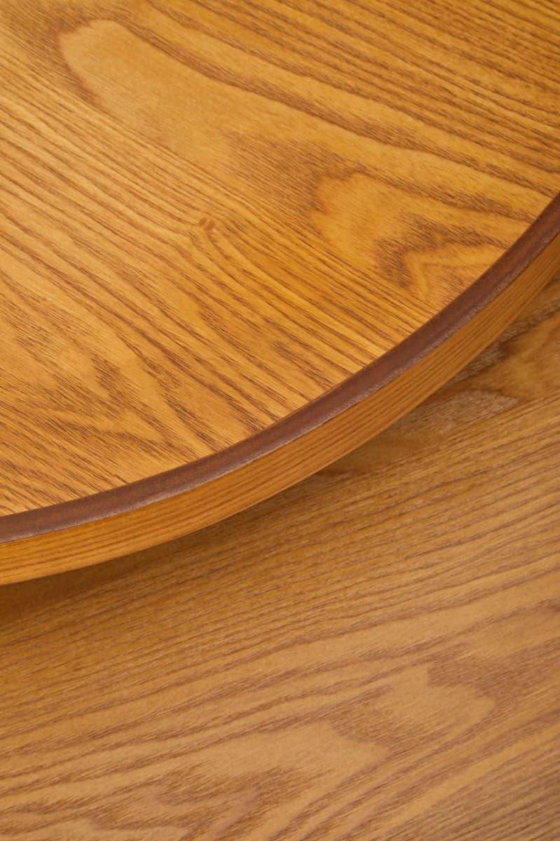 Closeup of round oak dining table top with natural wood grain finish