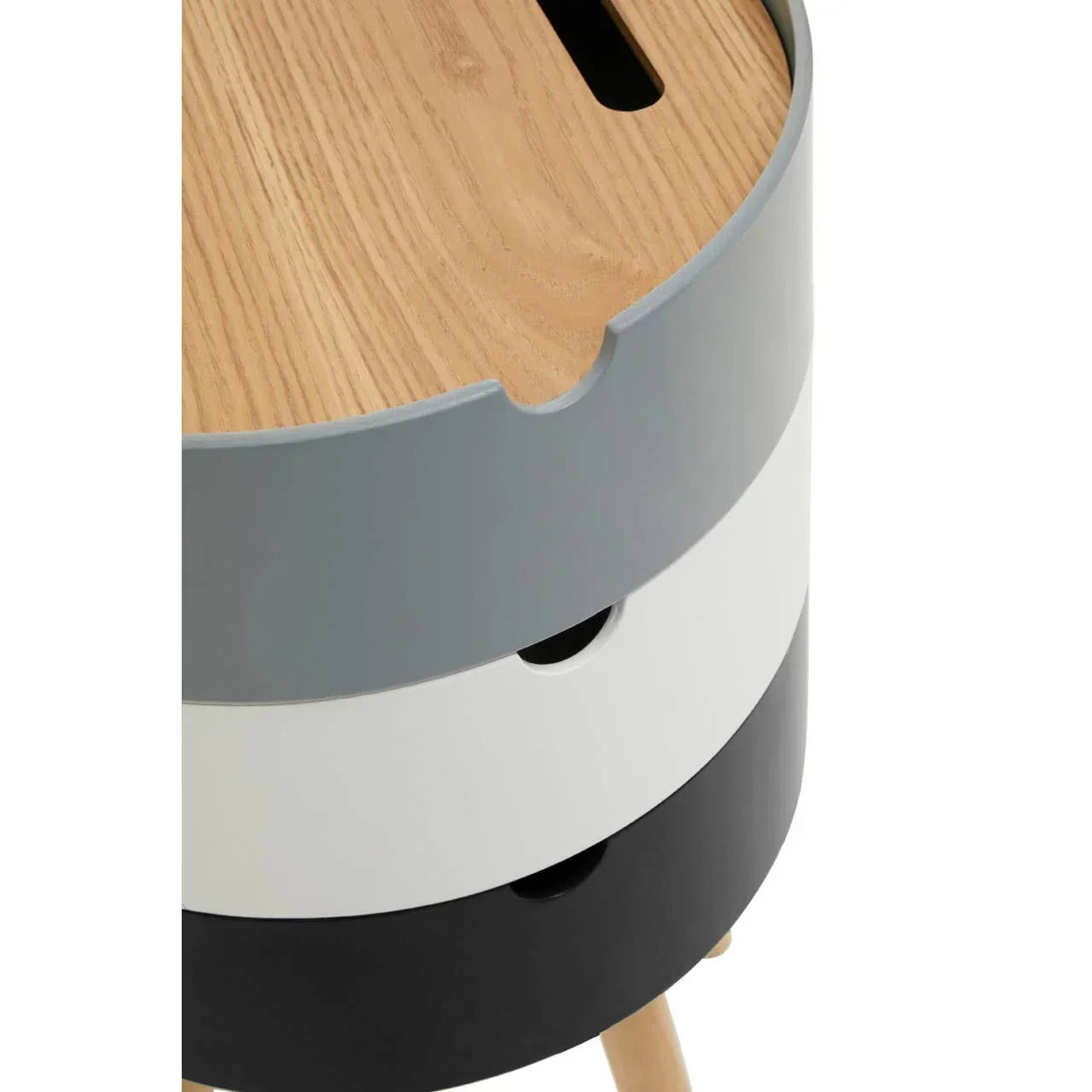Round side table with light wood top, grey, white and black stacked drawers, wooden legs