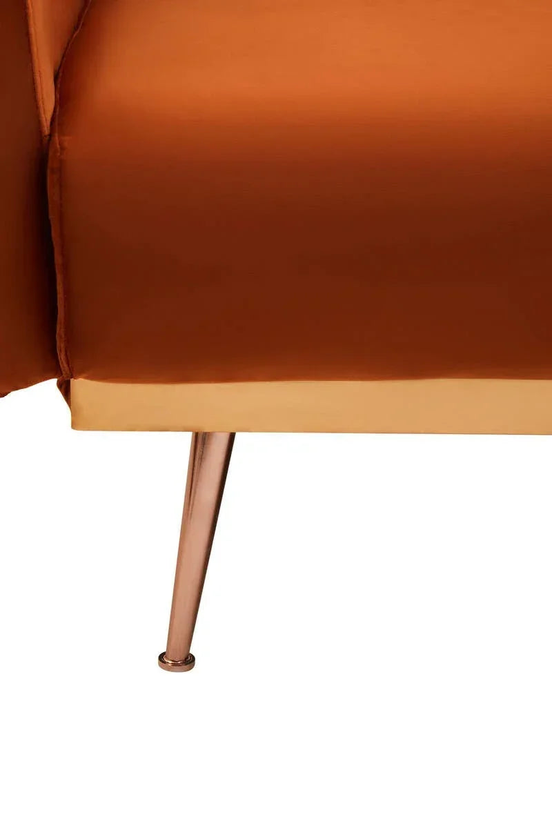 Closeup of orange sofa with gold trim and angled metallic leg