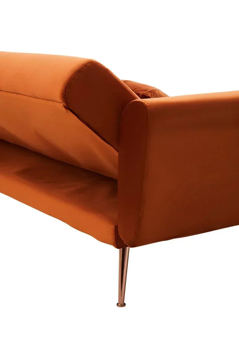 Close-up of orange velvet sofa with metal leg