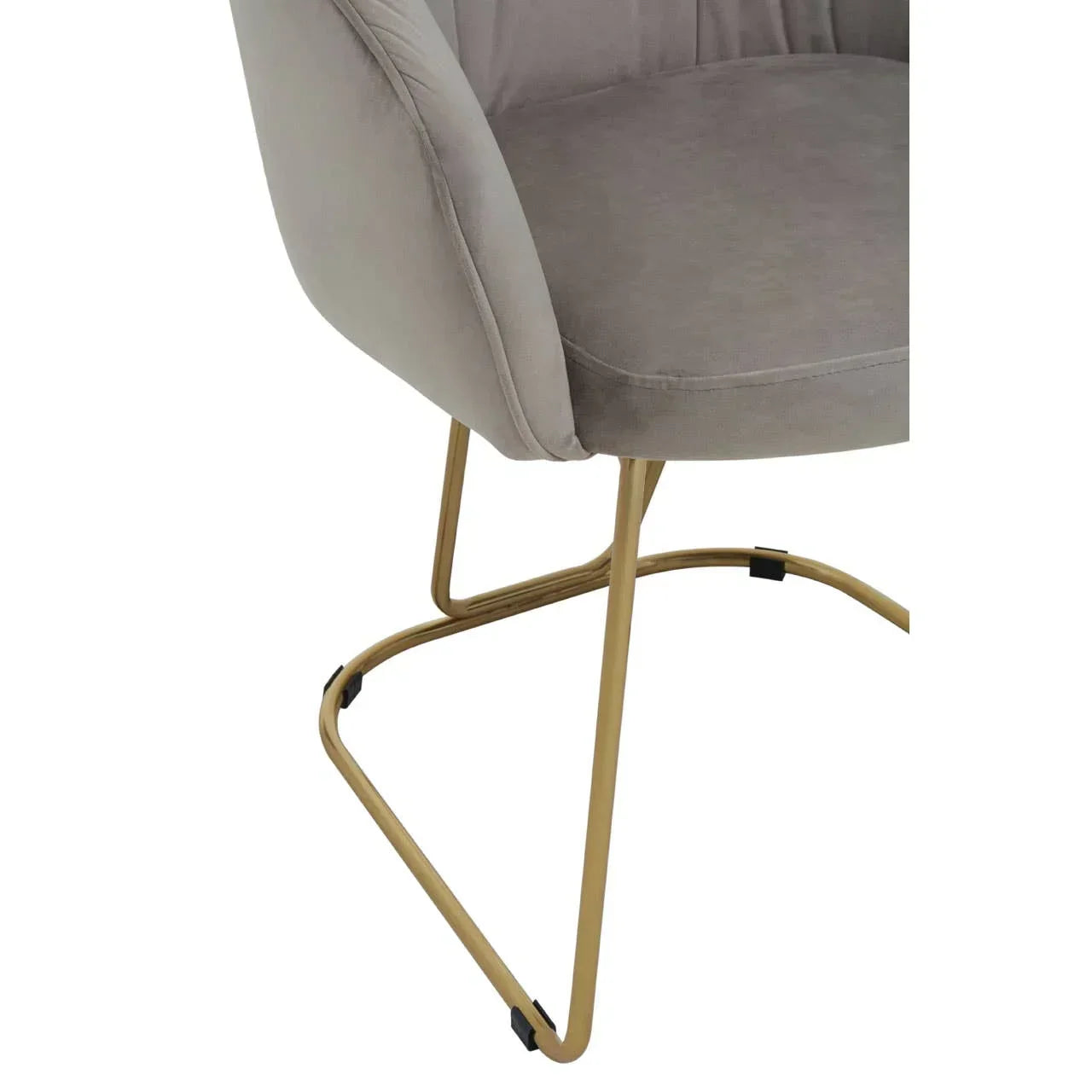 Grey velvet dining chair with gold metal legs, close-up side view of seat and base