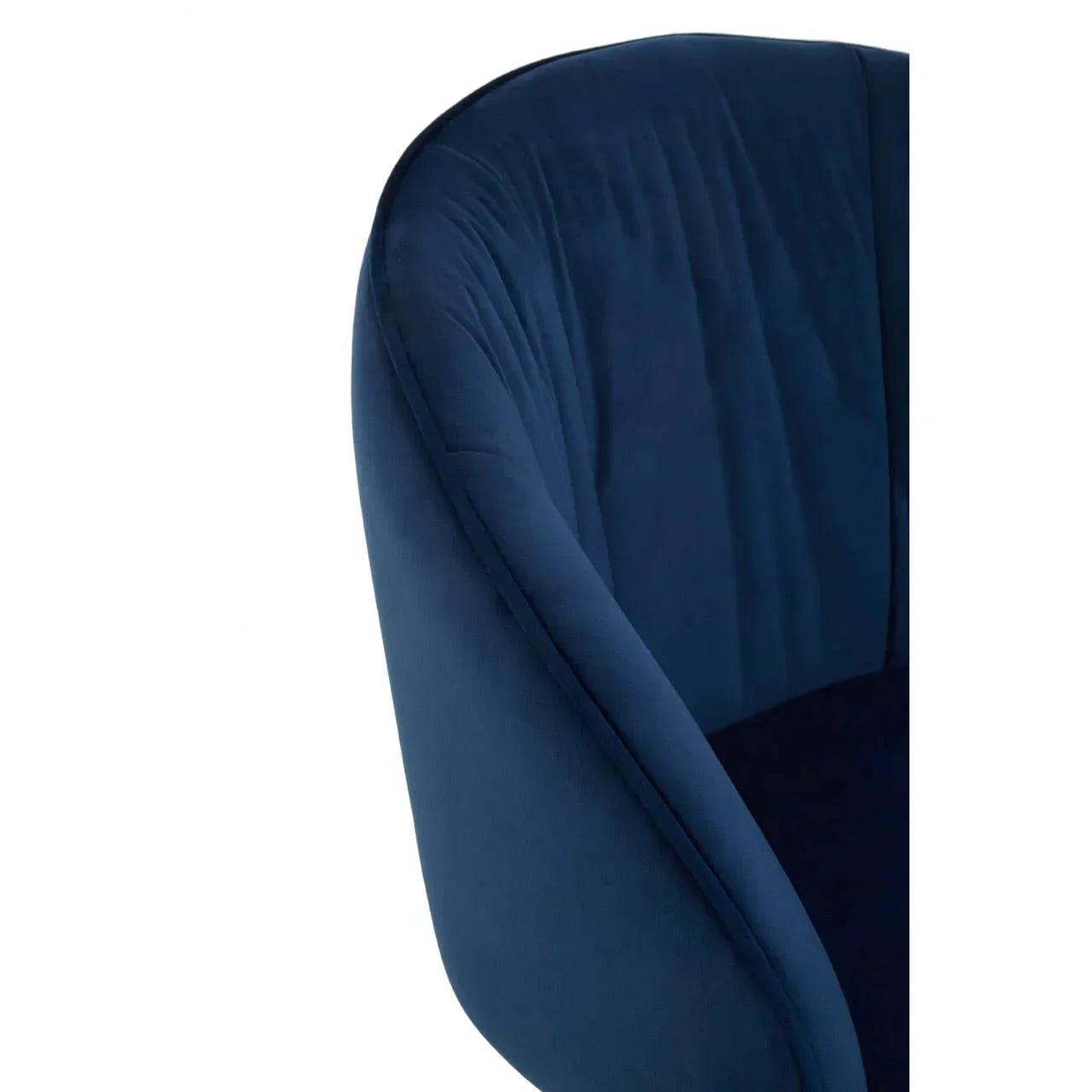 Close-up of blue velvet armchair with curved backrest and stitched upholstery
