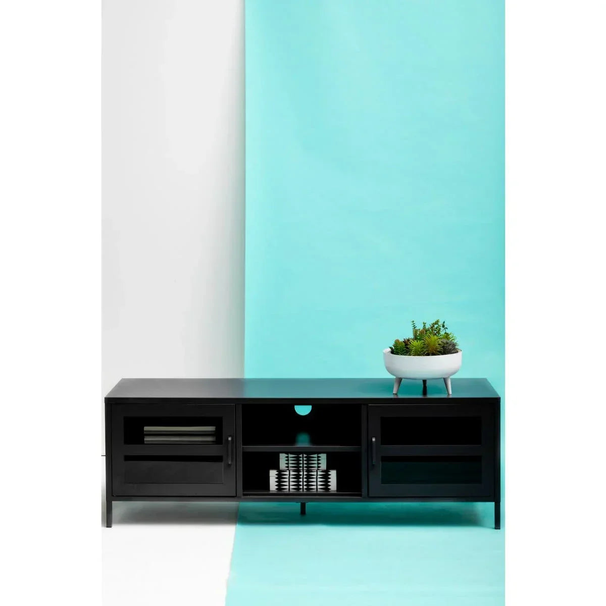Black TV unit with glass doors and white planter on top against blue and white backdrop