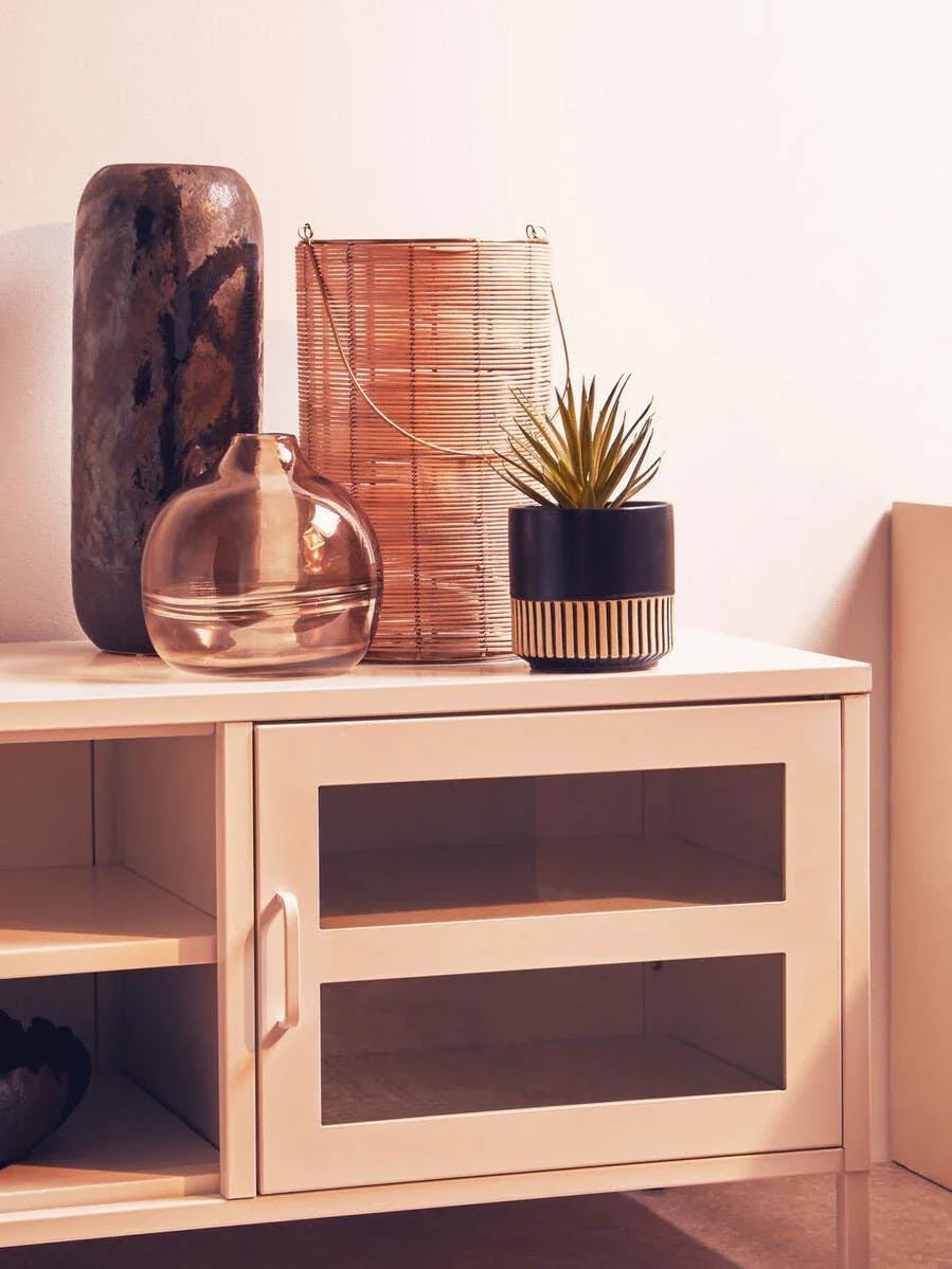 White sideboard with glass doors, decorative vases and potted plant on top
