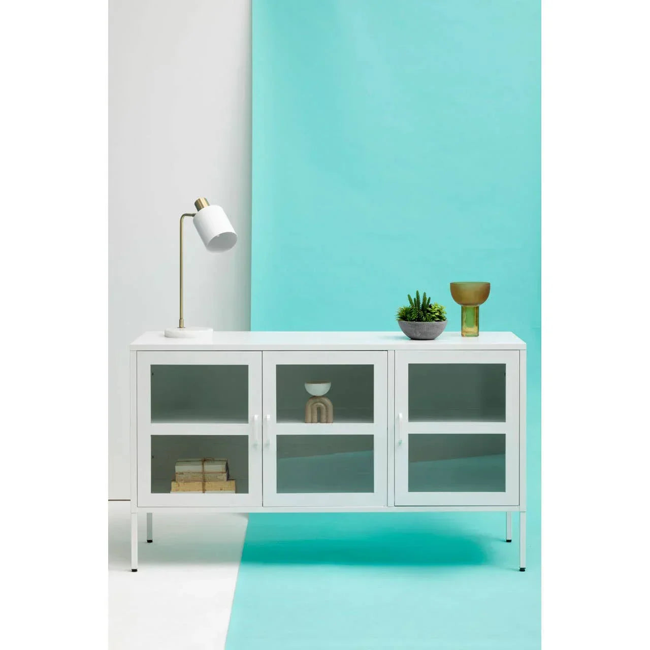 White sideboard with glass doors, styled with lamp, decor bowl, and plant on top