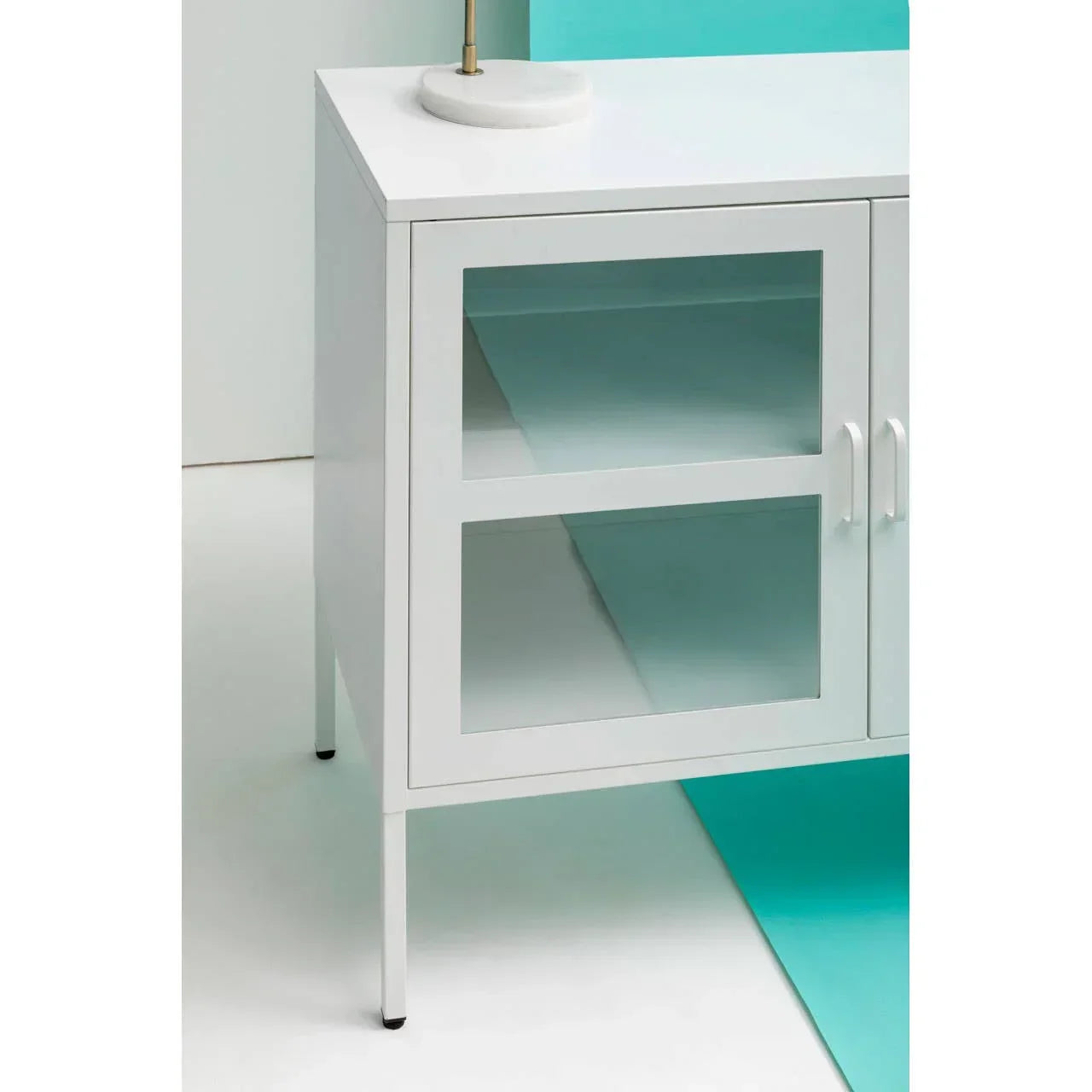 White glass door cabinet with silver handles and modern metal legs, close side view