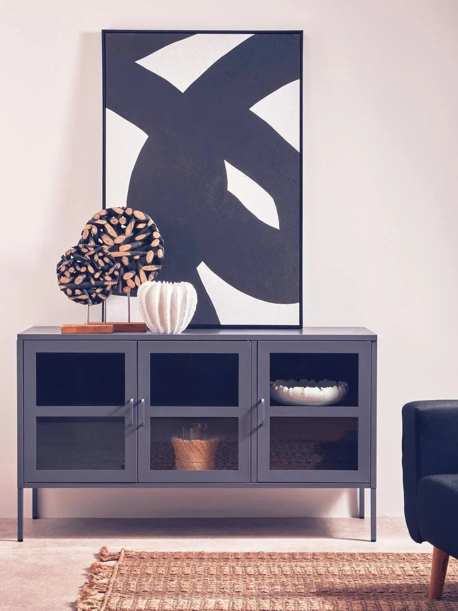 Charcoal glass door sideboard with decorative sculptures and abstract wall art in a modern room
