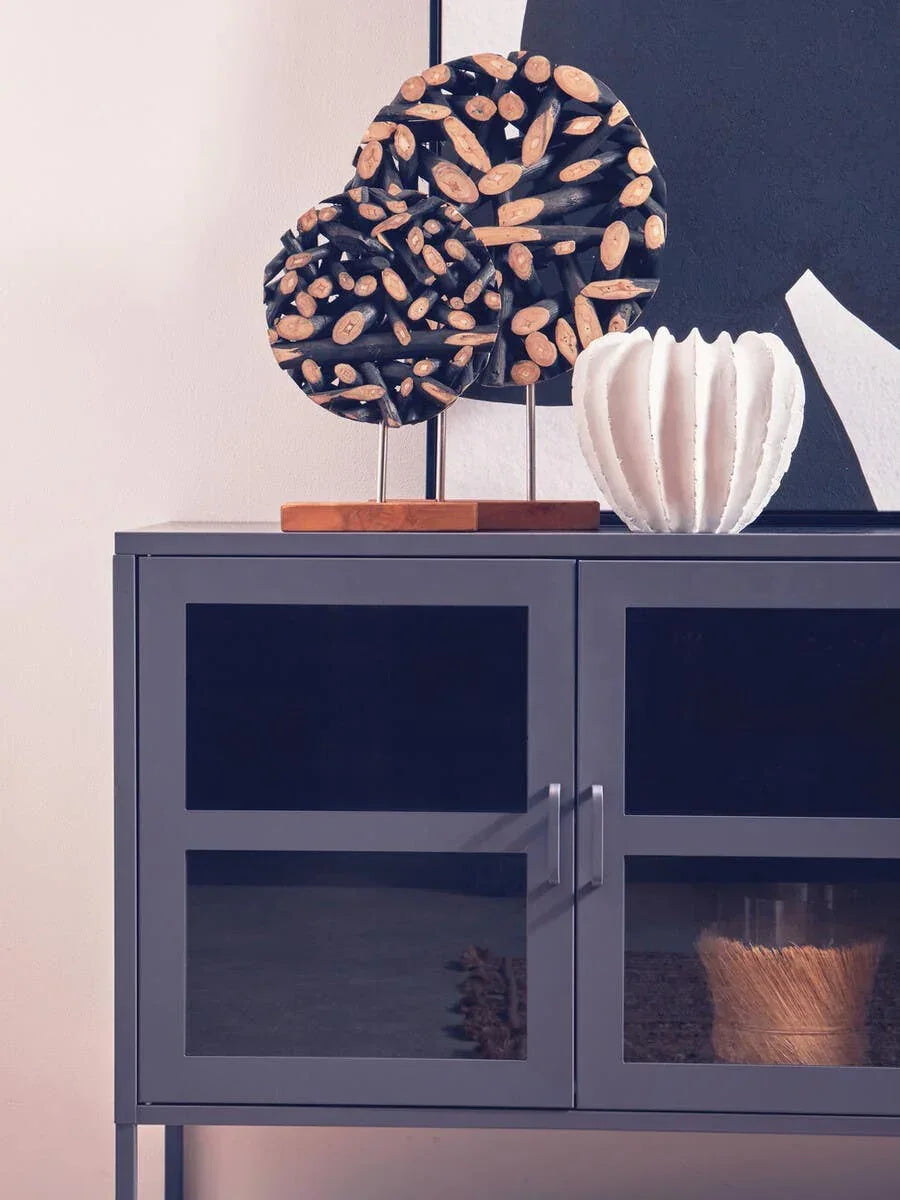 Modern grey storage cabinet with glass doors, wooden sculpture, and white ceramic vase on top