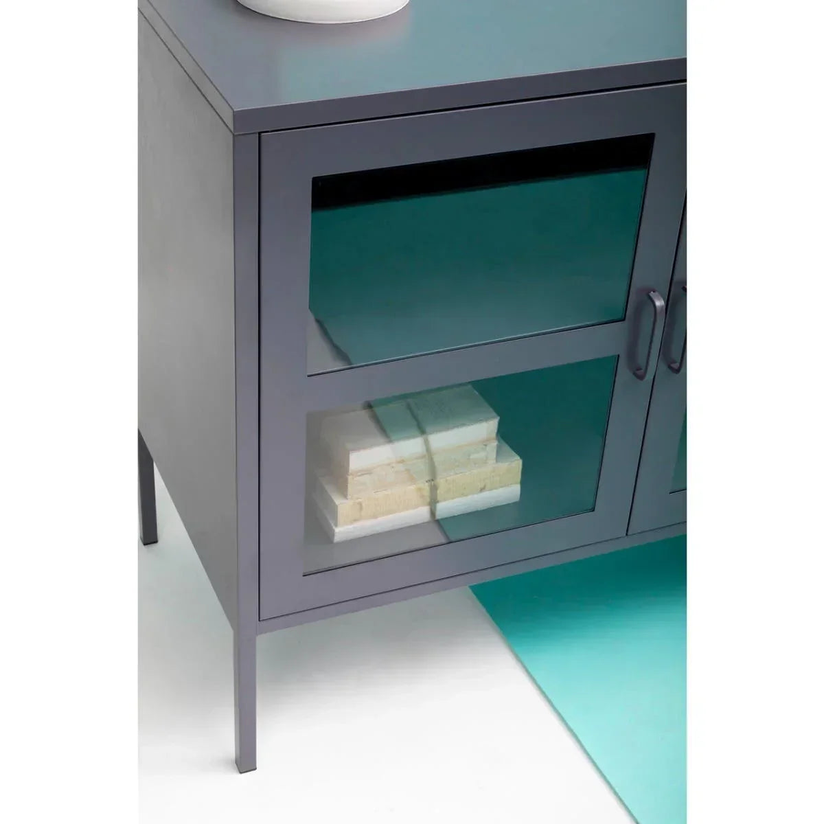 Grey metal sideboard with glass doors and stacked books on lower shelf