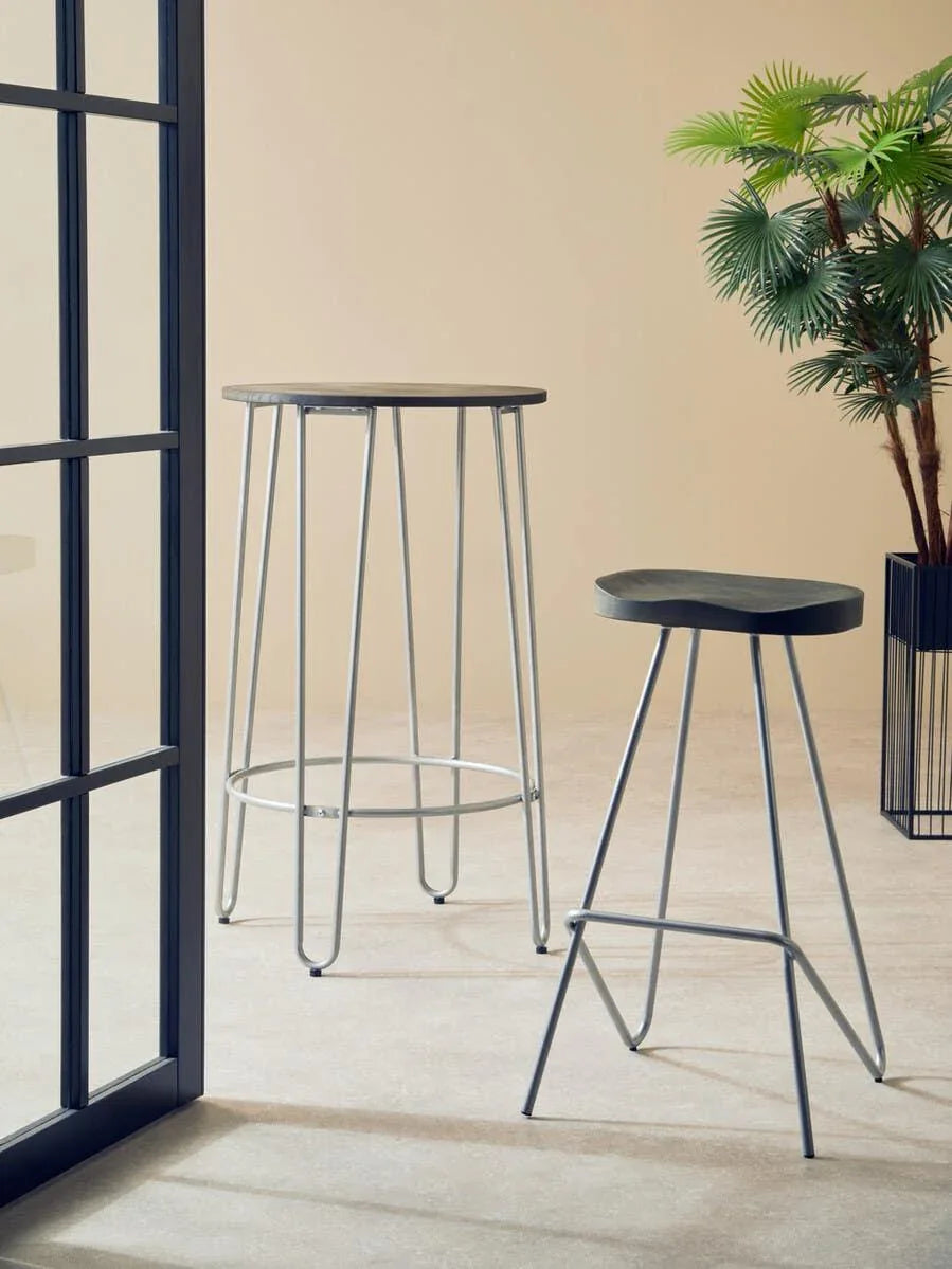 Modern bar table and bar stool with metal legs in minimalist room with potted plant