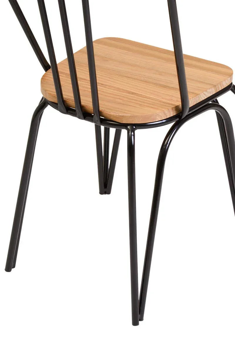 Closeup of dining chair with light wood seat and black metal frame