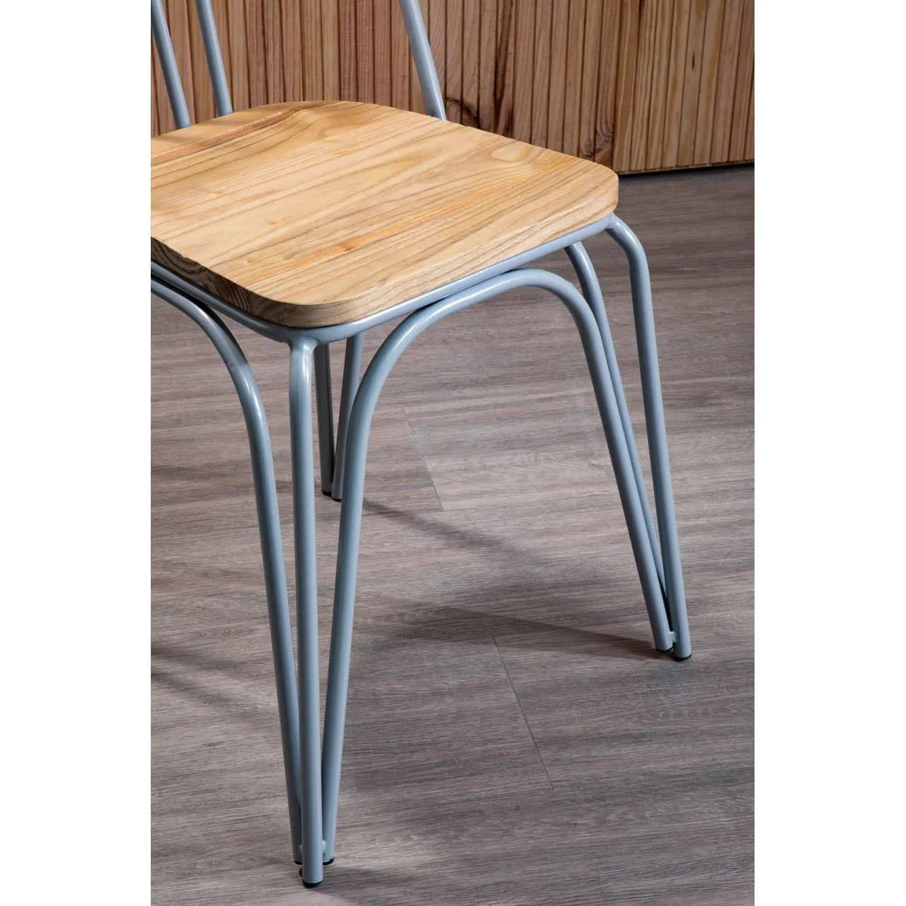 Wooden seat dining chair with grey metal legs on laminate floor