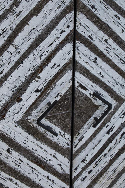 Rustic wooden cabinet doors with black handles and distressed chevron pattern