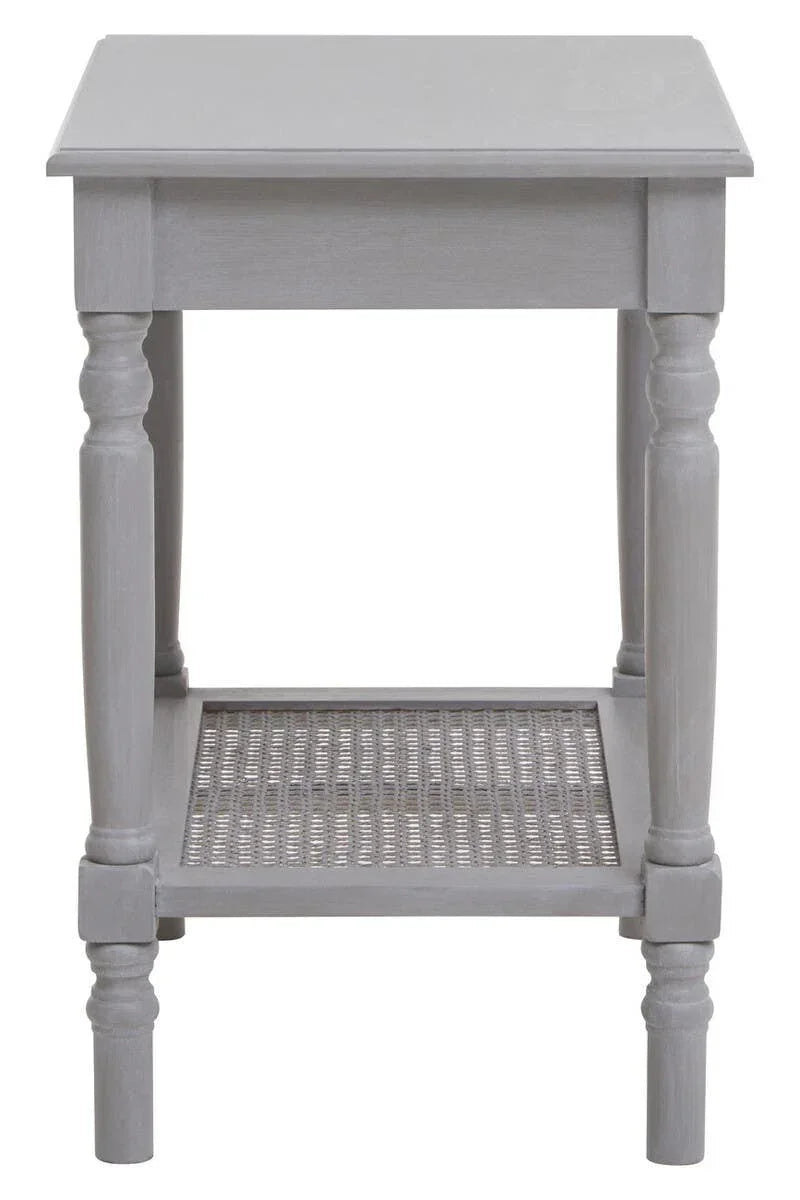 Grey wood side table with turned legs and lower rattan shelf, front view