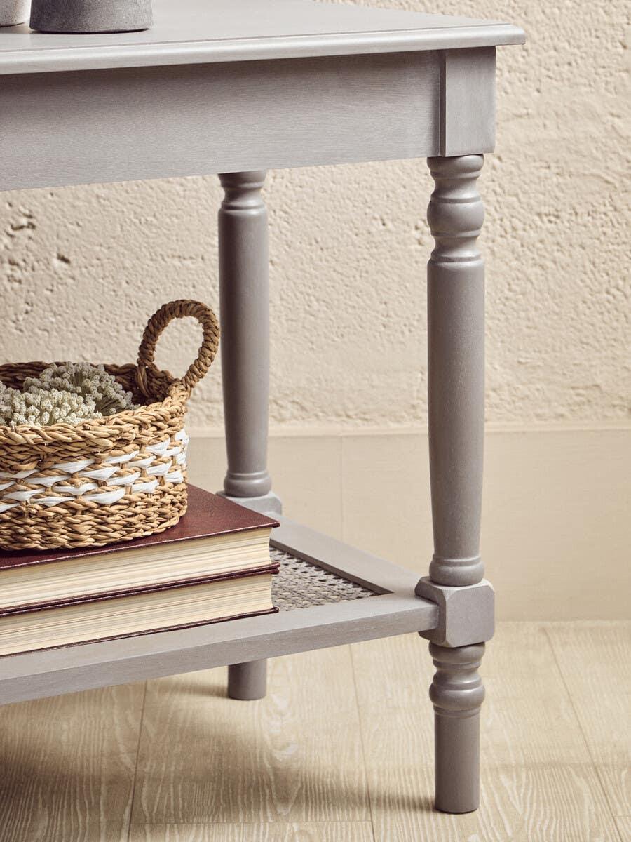 Grey wooden side table with turned legs, lower shelf holding books and woven basket
