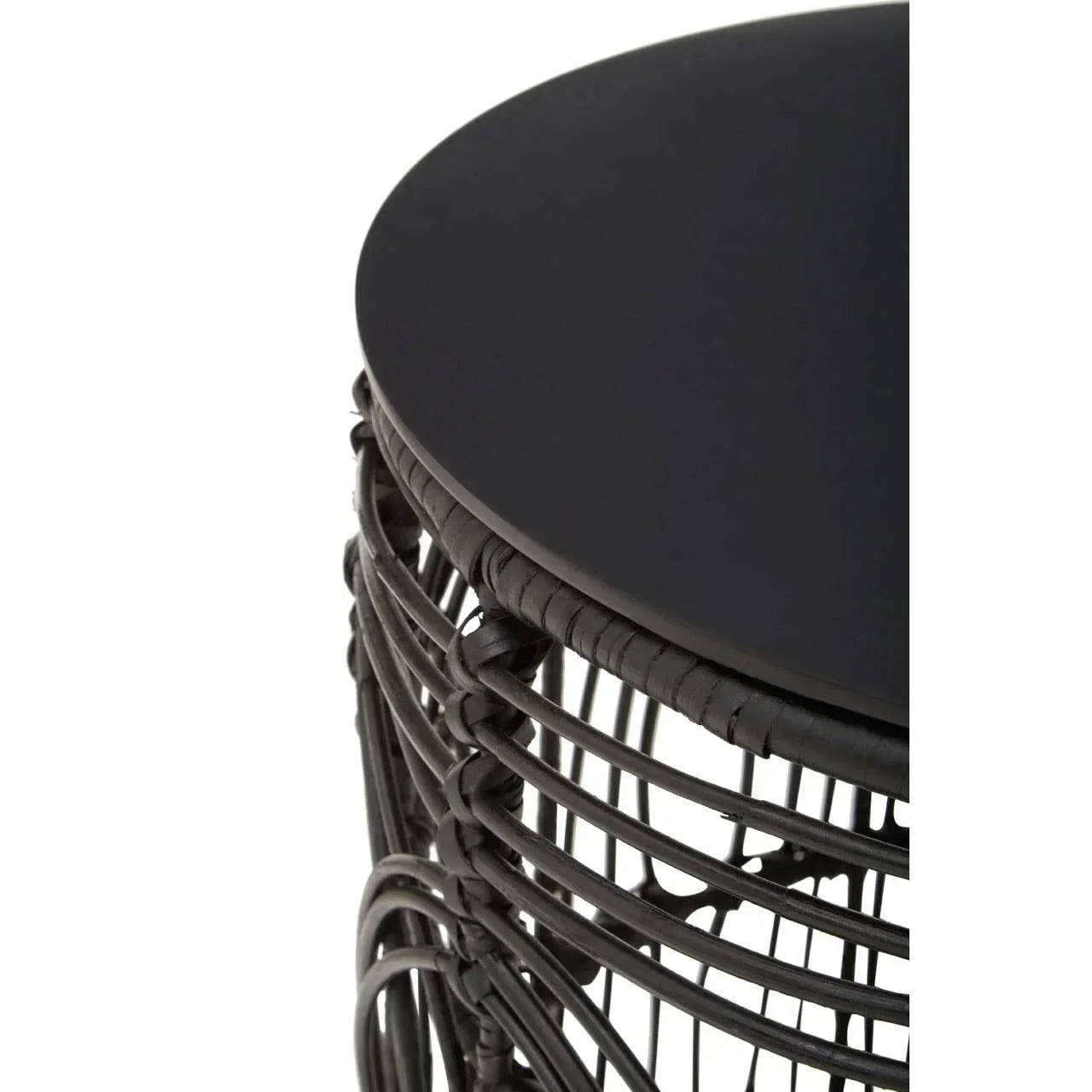 Black rattan side table with round solid top and woven base, close-up view