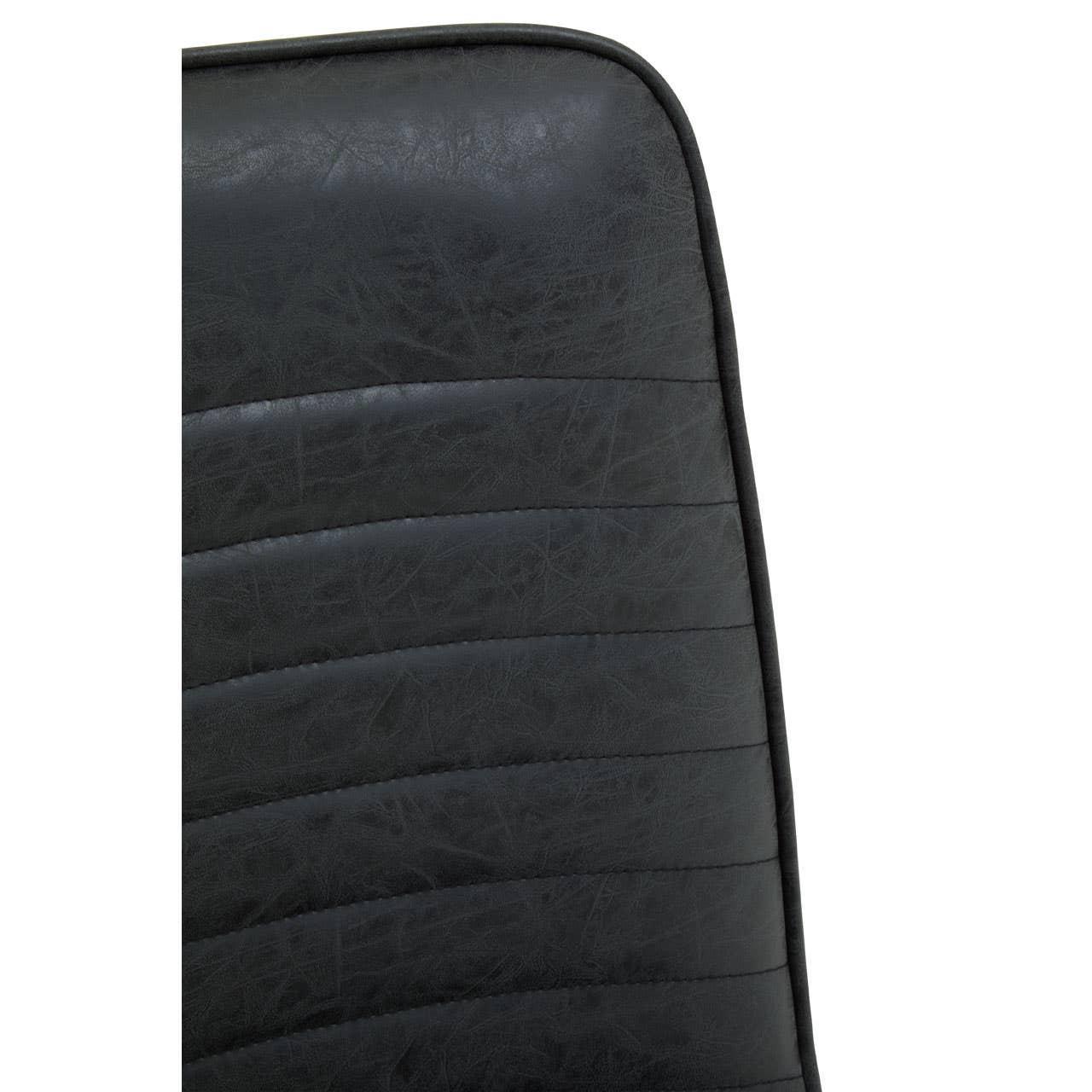 Closeup of black faux leather dining chair backrest with stitched vertical panels