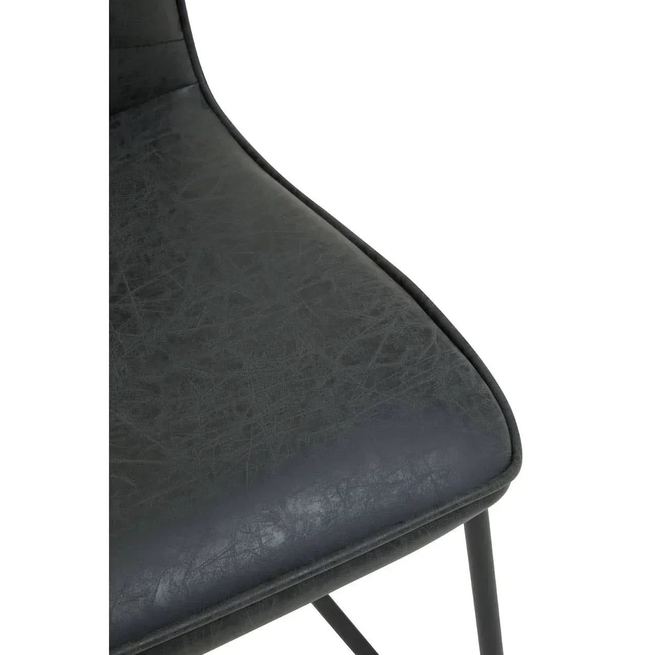 Close view of black faux leather dining chair seat with metal legs