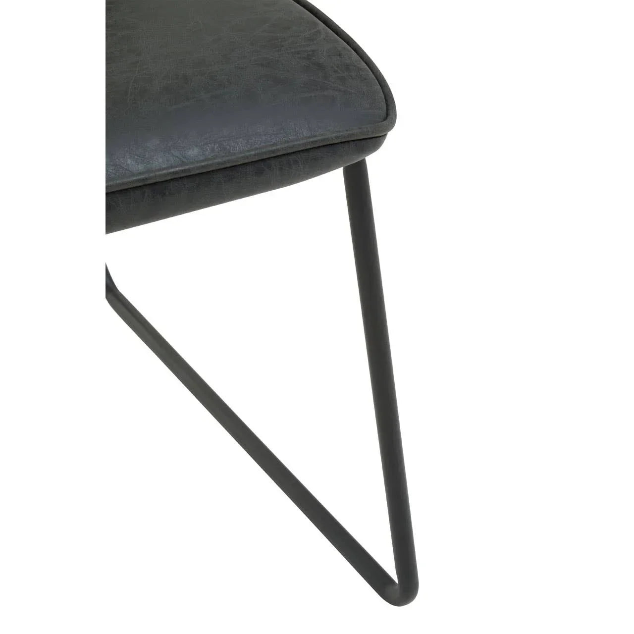 Close-up of grey dining chair seat with black metal angled leg