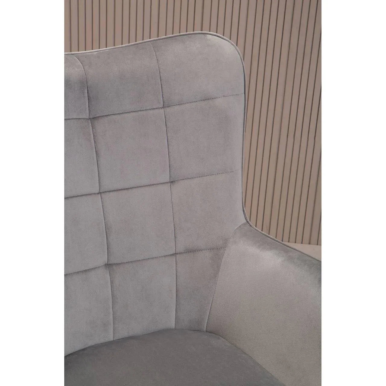 Grey velvet accent chair with quilted backrest and curved armrest in modern setting