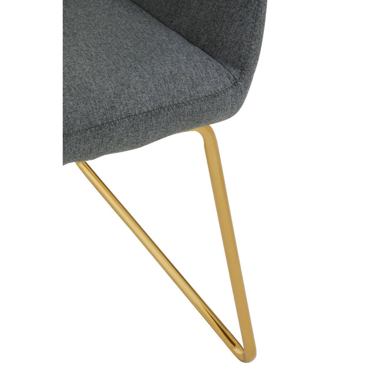 Grey fabric dining chair with gold metal legs, close-up of seat and frame