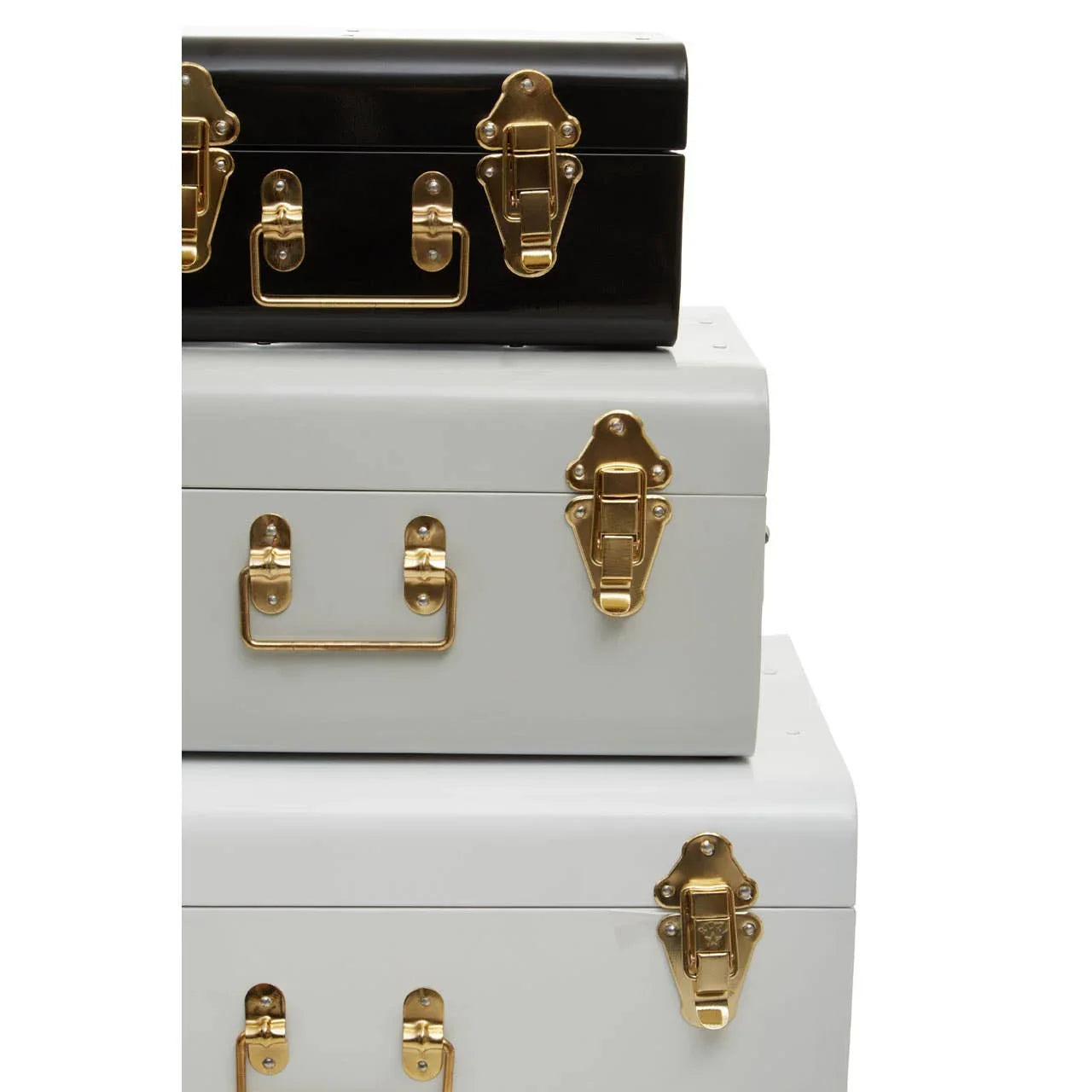 Stack of metal storage trunks in black and white with gold handles and latches